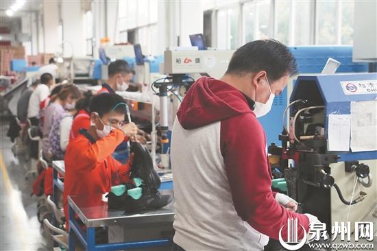 安踏員工正在車間忙碌地進行生產(chǎn)（文珍 攝）